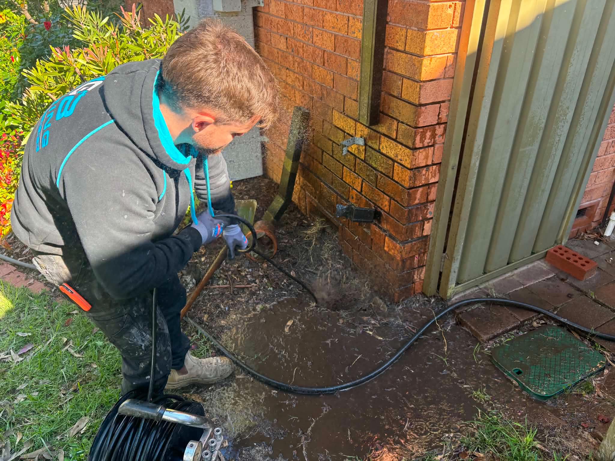 Rhys clearing a blocked drain with a high-pressure water jet